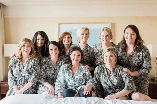 A group of women sitting on top of a bed.